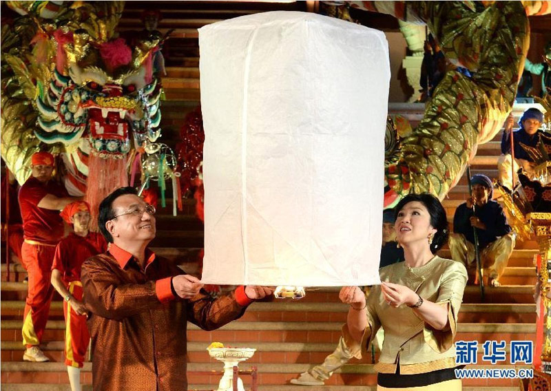 10月12日晚,中国国务院总理李克强在泰国清迈与泰国总理英拉身穿民族服装,共同放飞“孔明灯”,为中泰友好祝福。 新华社记者 刘建生 摄