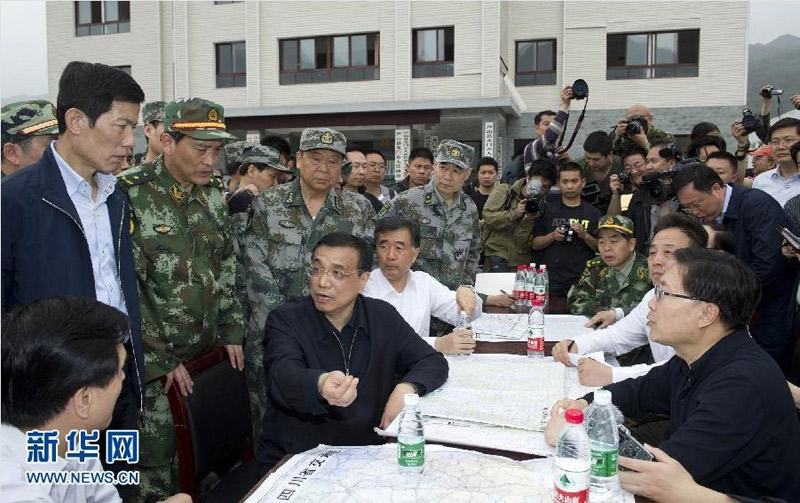 20日下午,在重灾区龙门乡政府前的空地上,李克强召开了现场会,听取当地干部的汇报。他说,重要的是保证今天晚上有帐篷住,同时要注意防止次生灾害造成新的伤亡。得知宝兴县已与外界中断了联系,他当即要求救灾部队和相关部门尽全力打通道路、恢复通信。新华社记者 黄敬文 摄