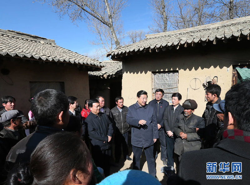 2月3日,中共中央总书记、中共中央军委主席习近平来到海拔2400多米、人均纯收入1400多元的定西市渭源县田家河乡元古堆村看望困难群众。图为在老党员马岗家的院子里,习近平和乡亲们共商脱贫致富之计,给大家拜年。新华社记者兰红光摄