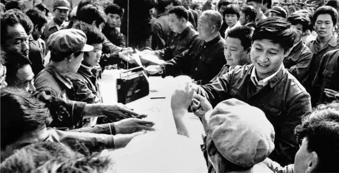 1984年10月,习近平在正定县城街头发放民意调查表。(图源:《让群众过上好日子——习近平正定足迹》)
