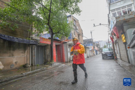　在台風“煙花”來襲期間，錢海軍來到浙江慈溪滸山街道金山社區，為社區排水泵進行接電，並給社區空巢孤寡老人送去應急照明手電（2021年7月25日攝）。新華社發（姚科斌攝）